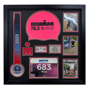 Ironman Bolton 2025 round DIY Triathlon frame for displaying medal, bib, swimming cap, and event times.